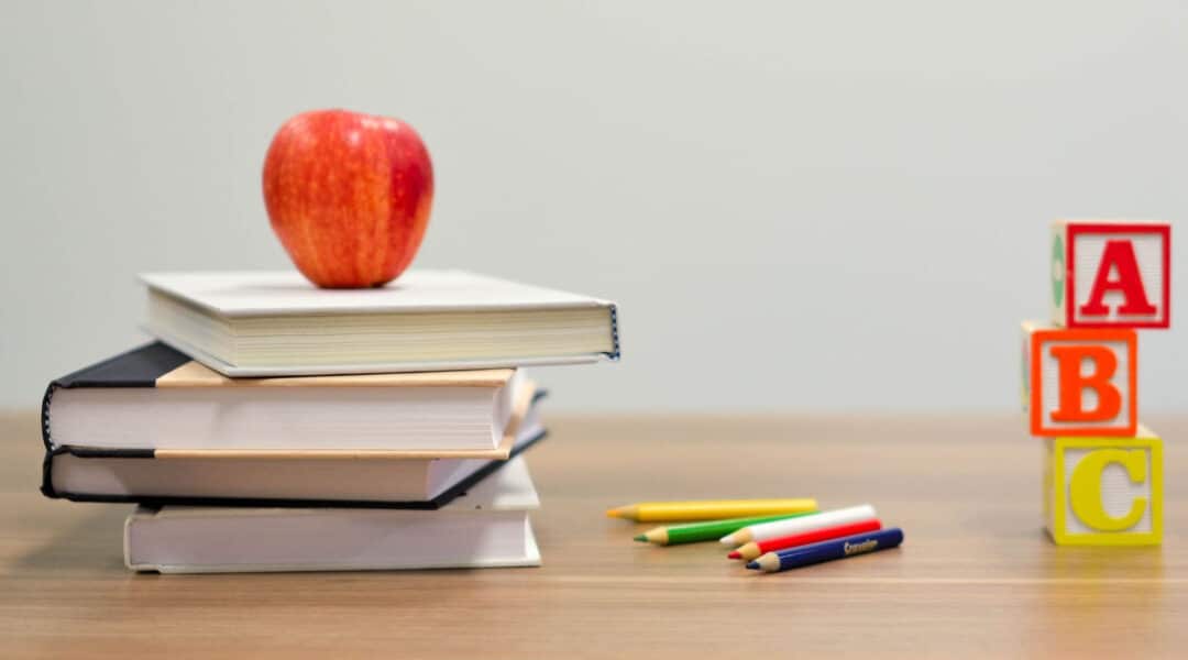 4 books piled up with pencils showing techniques classroom management